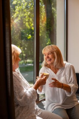 close-up-smiley-women-holding-cups